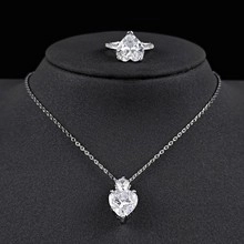 Elegant silver heart necklace and ring set with sparkling zircons on a black bust