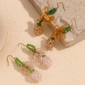 Macro shot of colorful beaded fruit earrings on natural stone with soft shadows