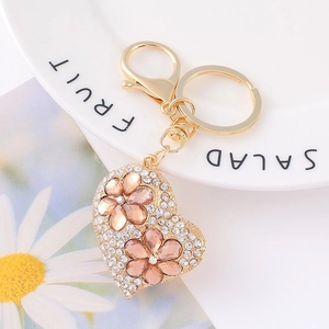 Macro shot of gold heart keychain with sparkling white crystals and pink rhinestone flowers