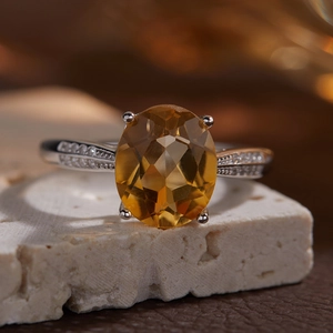 Detail view of oval cut natural citrine stone on silver ring with side stones