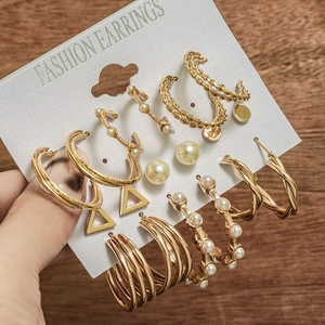 Détail d'un lot de 6 paires de boucles d'oreilles dorées avec perles sur carte de présentation