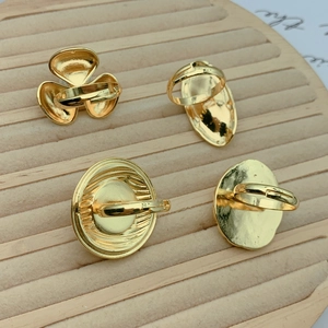 Detailed view of four adjustable gold ring bases with clover and oval shapes on a velvet tray