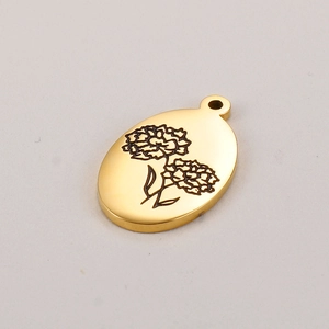 Détail macro d'un pendentif ovale doré avec gravure d'hydrangée et métal poli