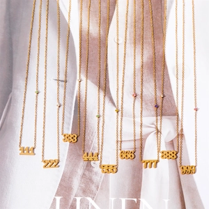 Gold plated titanium steel angel number necklaces with colored zircons on fashion magazine
