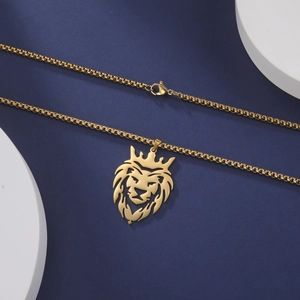 Detailed view of a gold lion head pendant with crown on a geometric navy background