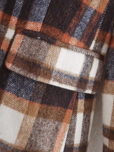 Detailed close-up of checkered wool coat pocket with orange and brown tweed fabric