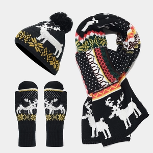 Detail of winter knit set featuring white reindeer jacquard pattern on black scarf and gloves