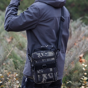 Outdoor tactical camouflage crossbody bag with adjustable strap shown in nature