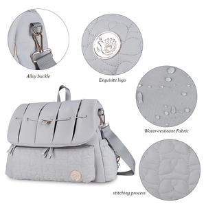 Close-up of waterproof fabric and durable alloy buckle on light gray diaper backpack