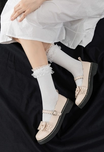 Détail de chaussettes blanches à dentelle avec chaussures Mary Jane beiges à cœur