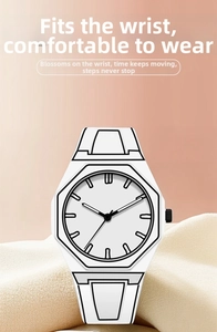 Detail of octagonal white quartz watch with black hands and minimalist seamless strap
