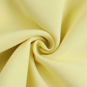 Gros plan sur le tissu mousseline jaune clair avec une texture plissée en spirale