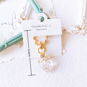 Detail of 6.6cm iridescent strawberry keychain with resin texture and golden clasp