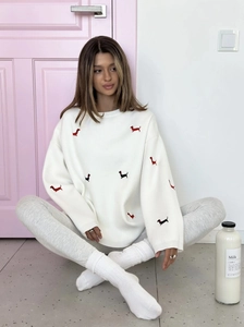 Detail of white knit sweater featuring red and black dachshund embroidery with a round neck