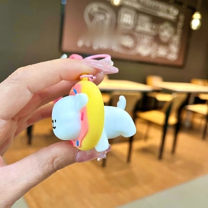 Side view of a cute cartoon puppy keychain with a doughnut hat on a blurry background