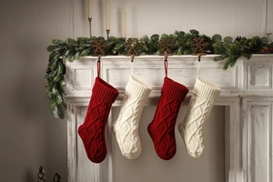 Close-up of cable knit Christmas stockings in red and white hanging on fireplace mantel