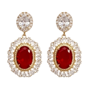 Close-up of luxury gold-plated oval red ruby earrings with white crystal halo detail