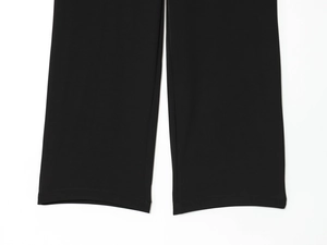 Close-up detail of black straight-leg trousers showing premium stitching and fabric texture