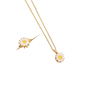 Elegant gold daisy jewelry set with white enamel petals and yellow core on white background