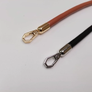 Close-up of leather handbag straps in brown and black with gold and silver hooks