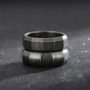 Close-up of stacked vintage silver rings with brushed metal texture and geometric edges