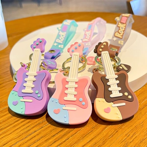 Cartoon guitar silicone keychains with Rock and Roll wristbands on wooden surface