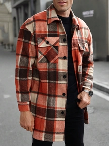 Detailed macro view of orange plaid wool shacket showing button chest pockets and fabric