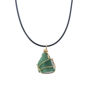 Detail of a natural green stone pendant with gold wire wrapping and black cord necklace