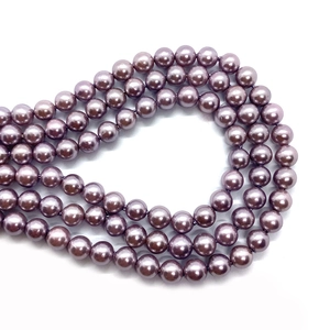 Macro shot of 4-10mm violet imitation glass pearls showing polished surface and drill holes