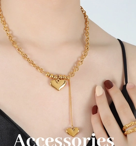 Détail du collier à grosse chaîne dorée 18K avec pendentifs cœur et bagues texturées