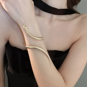 Detailed view of a gold snake-shaped upper arm cuff bracelet with textured scale finish