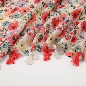 Close-up of bohemian floral print scarf with vibrant red tassels and cotton-linen texture