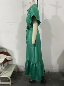 Détail de la robe verte avec ourlet à volants élégant et ceinture à la taille