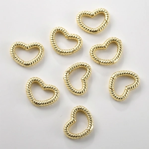 Dettaglio di fermagli a molla a forma di cuore placcati in oro con trama a corda