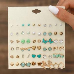 Close-up of assorted stud earrings set with bow, flower, pearl and heart shapes