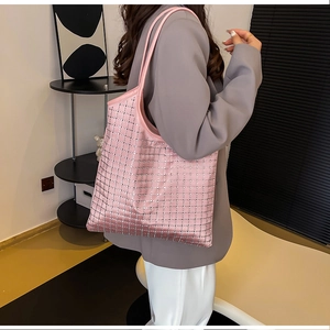 Detail of pink satin tote bag with silver rhinestone grid pattern worn on shoulder