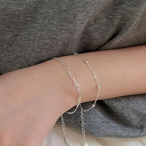 Detail of silver Figaro and beaded bracelet set on wrist with adjustable chain extension