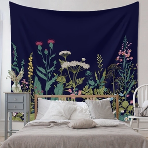 Detail of bohemian floral tapestry hanging above bed in a cozy bedroom setting