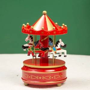 Detail of red and gold carousel music box featuring hand-painted horses on white surface
