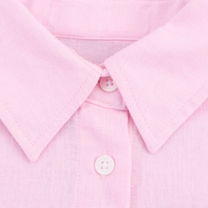 Detailed close-up of pink linen shirt collar showing fabric texture and white buttons