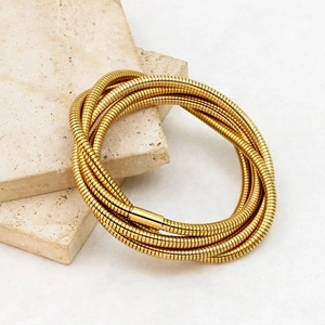 Detail of 18K gold-plated multi-layer snake chain bracelet on marble stones