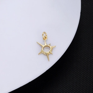 Macro view of a 18K gold plated starburst pendant with a high-polished metallic finish