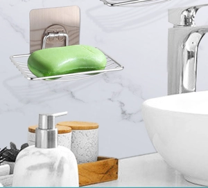 Wall-mounted stainless steel soap dish with self-adhesive strip on marble wall