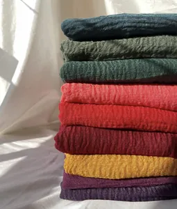 Macro detail of textured crinkle scarves in nine vibrant colors with pleated fabric finish