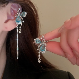 Détail du protège-oreille papillon en strass bleu ciel avec élégant gland long sur modèle