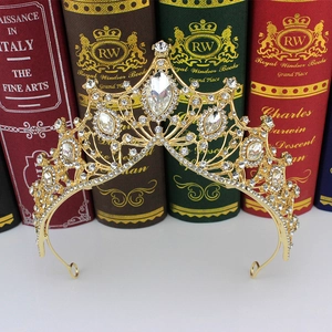 Close-up of golden Baroque bridal crown with sparkling crystals on vintage book background