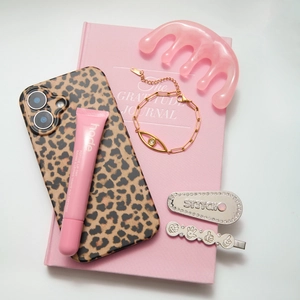Flat lay del bracciale occhio del diavolo in oro 18K con cover leopardata e accessori
