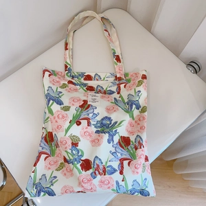 Detail of floral canvas tote bag showing rose and iris prints with reinforced handle
