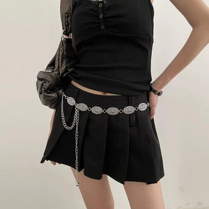 Detail of vintage silver butterfly oval waist chain on a black pleated skirt