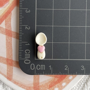 Close-up of mini resin spoon with pink heart, size 3.5cm shown on a measurement grid